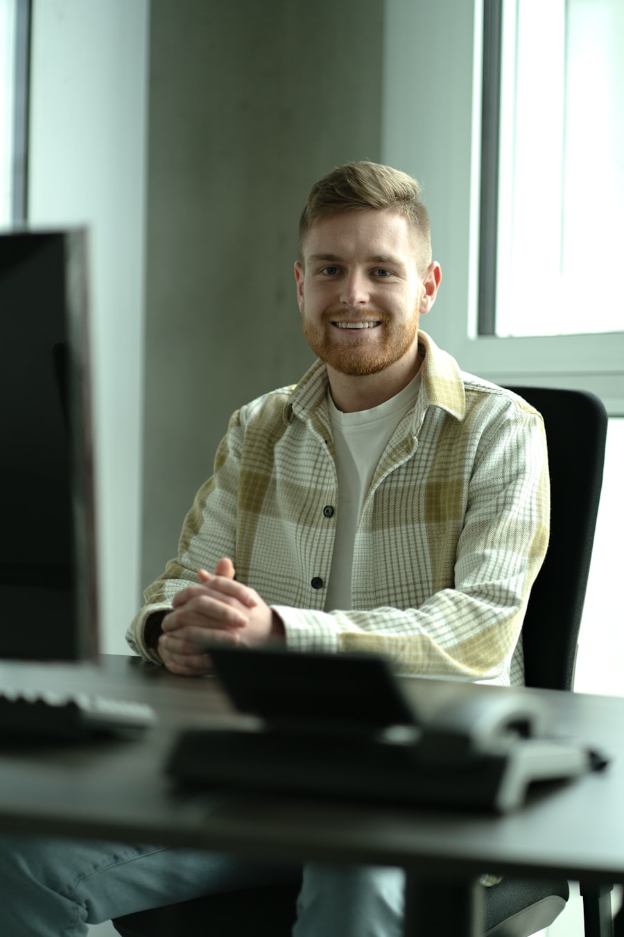 Software engineer smiling at his office desk